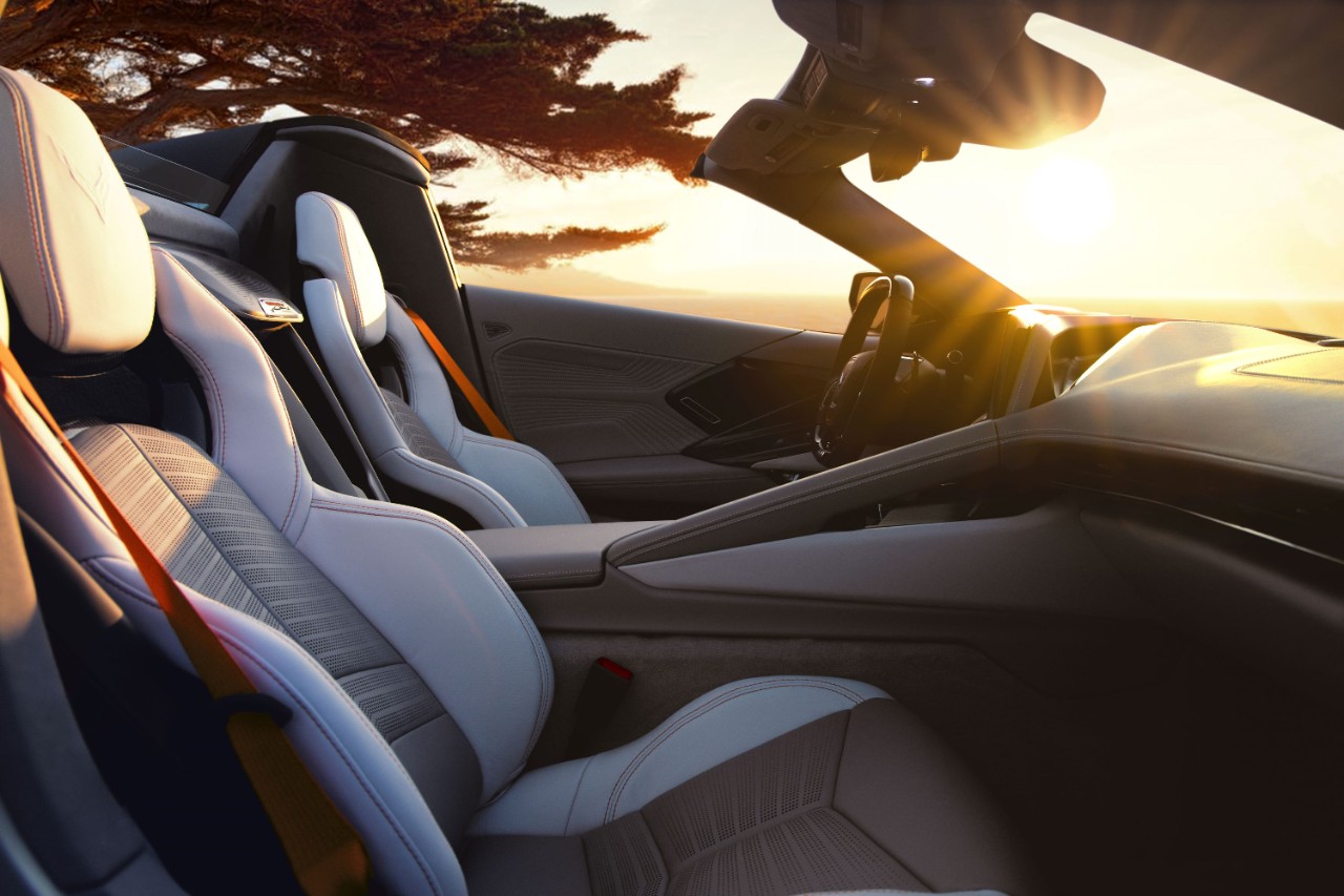 The interior and bucket seats of a silver convertible sports car.