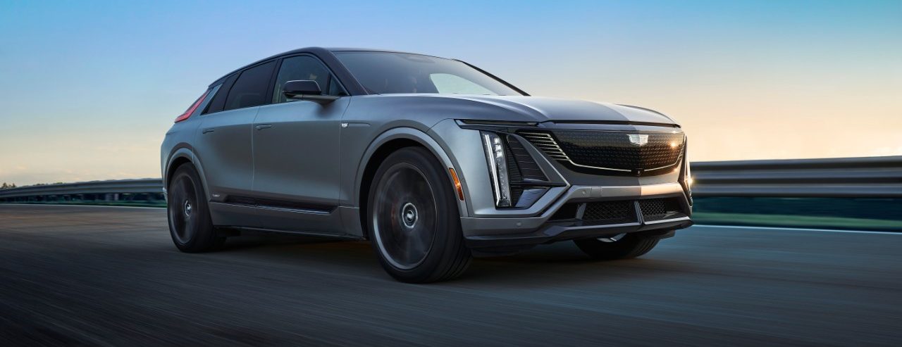 2026 Cadillac LYRIQ-V in silver in motion on road, right (passenger) side 3/4 view